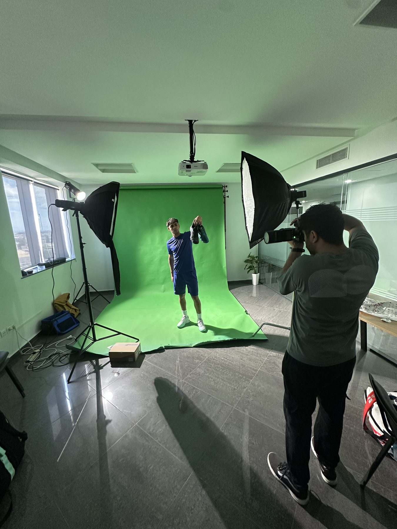 Photographe en plein shooting sur fond vert au Light Zone Studio